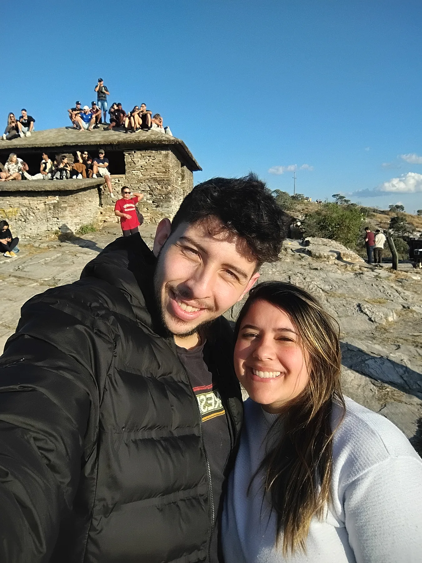 Casal sorrindo durante uma aventura no alto